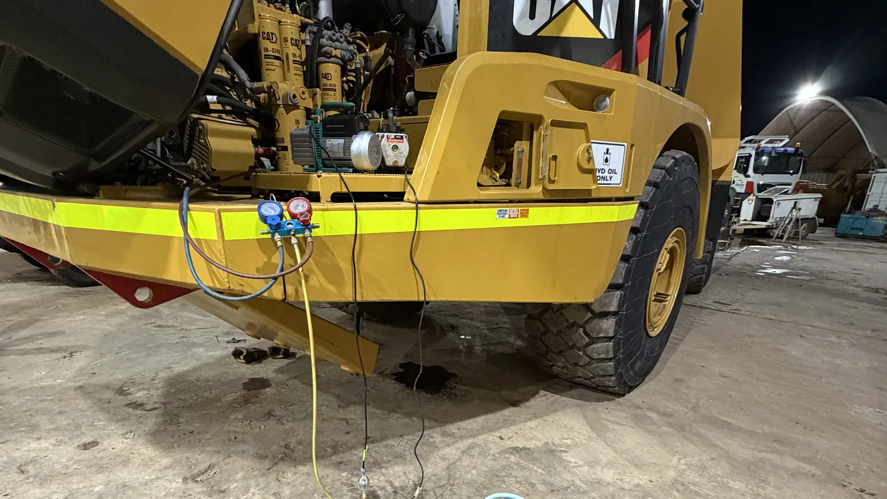 Manifold gauges connected to the air conditioning on a CAT haul truck