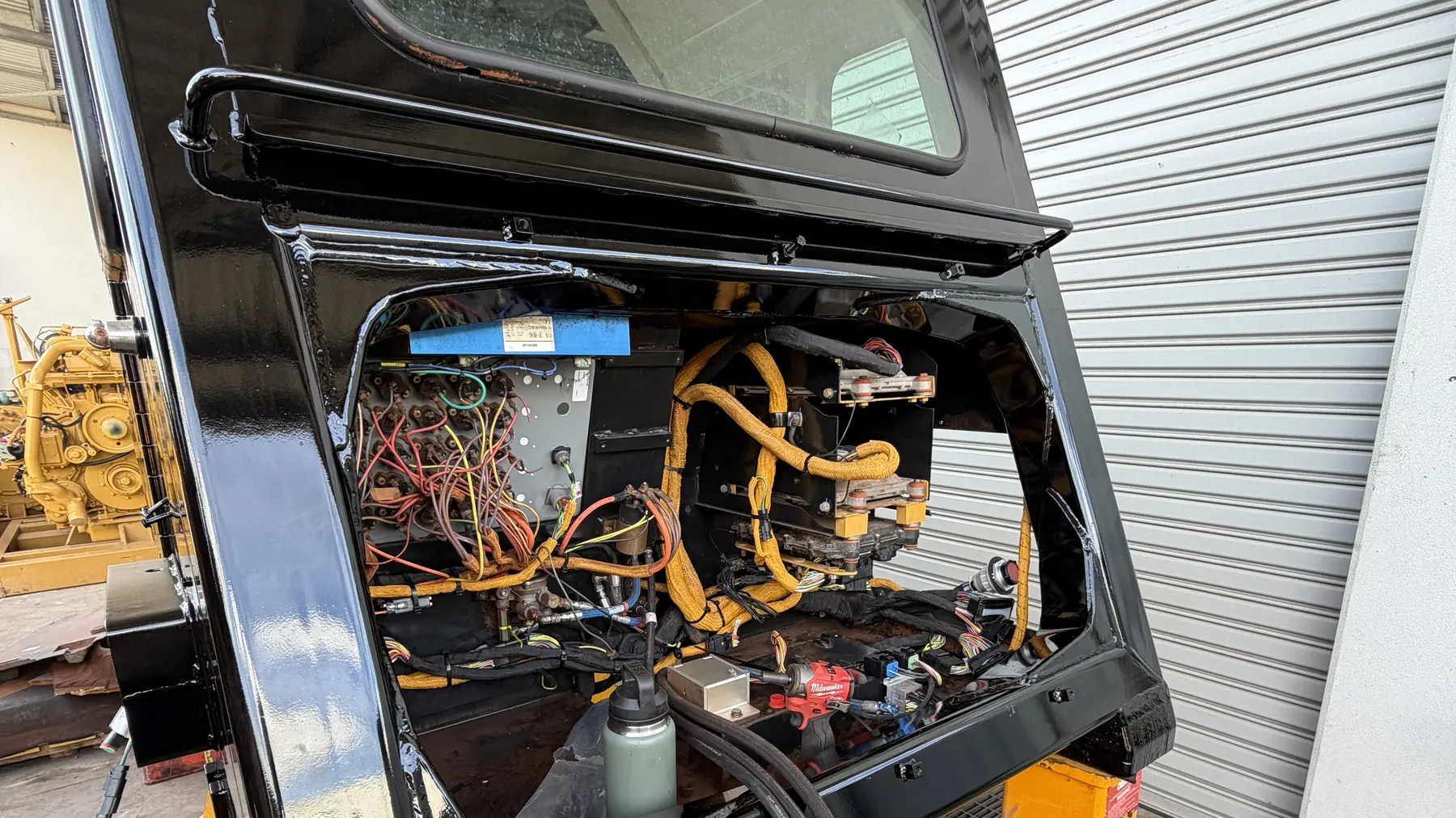 Machine cab opened up on stands showing the wiring behind the panel