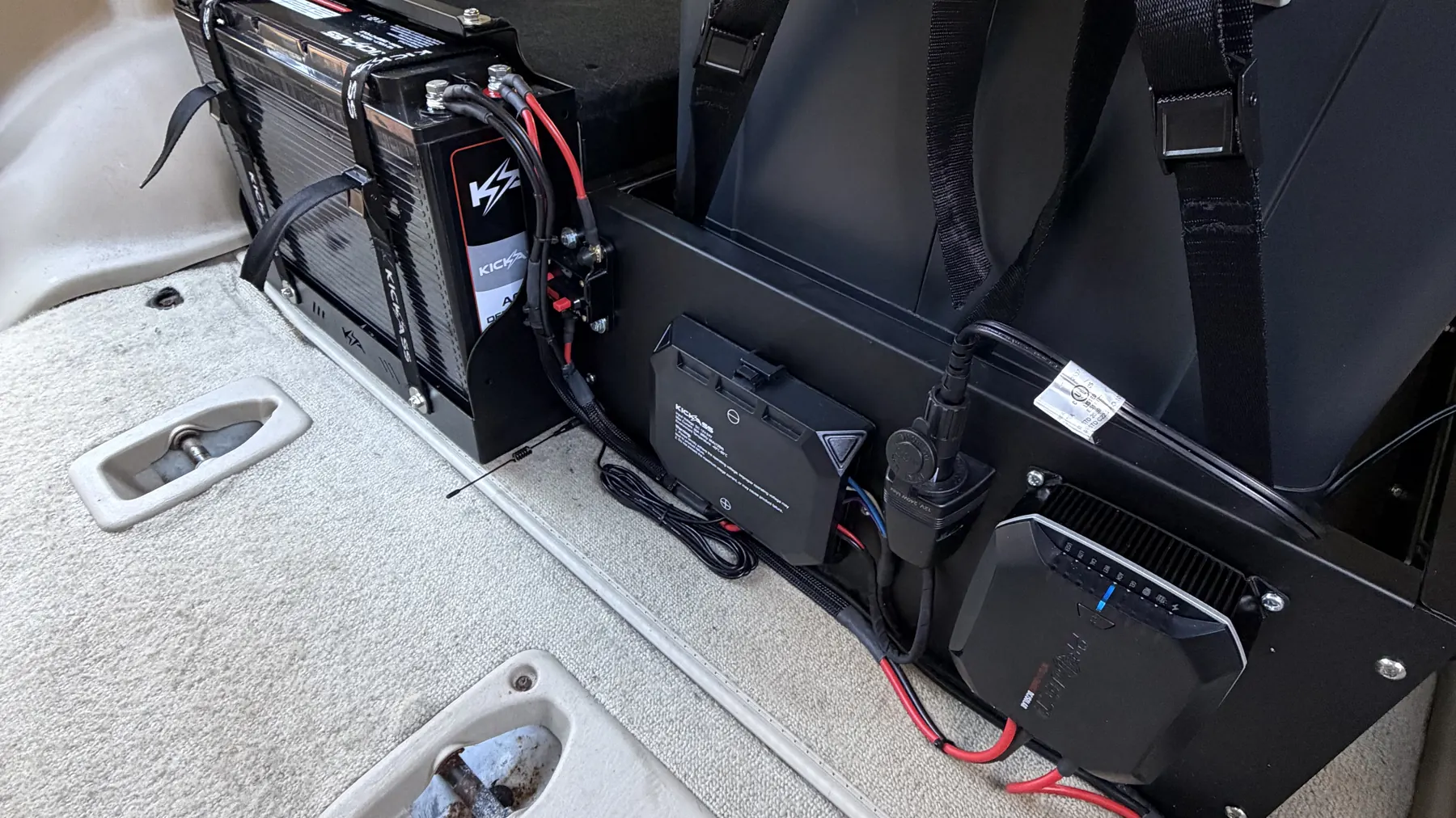 Dual battery setup, isolator and amplifier installed behind a vehicle seat