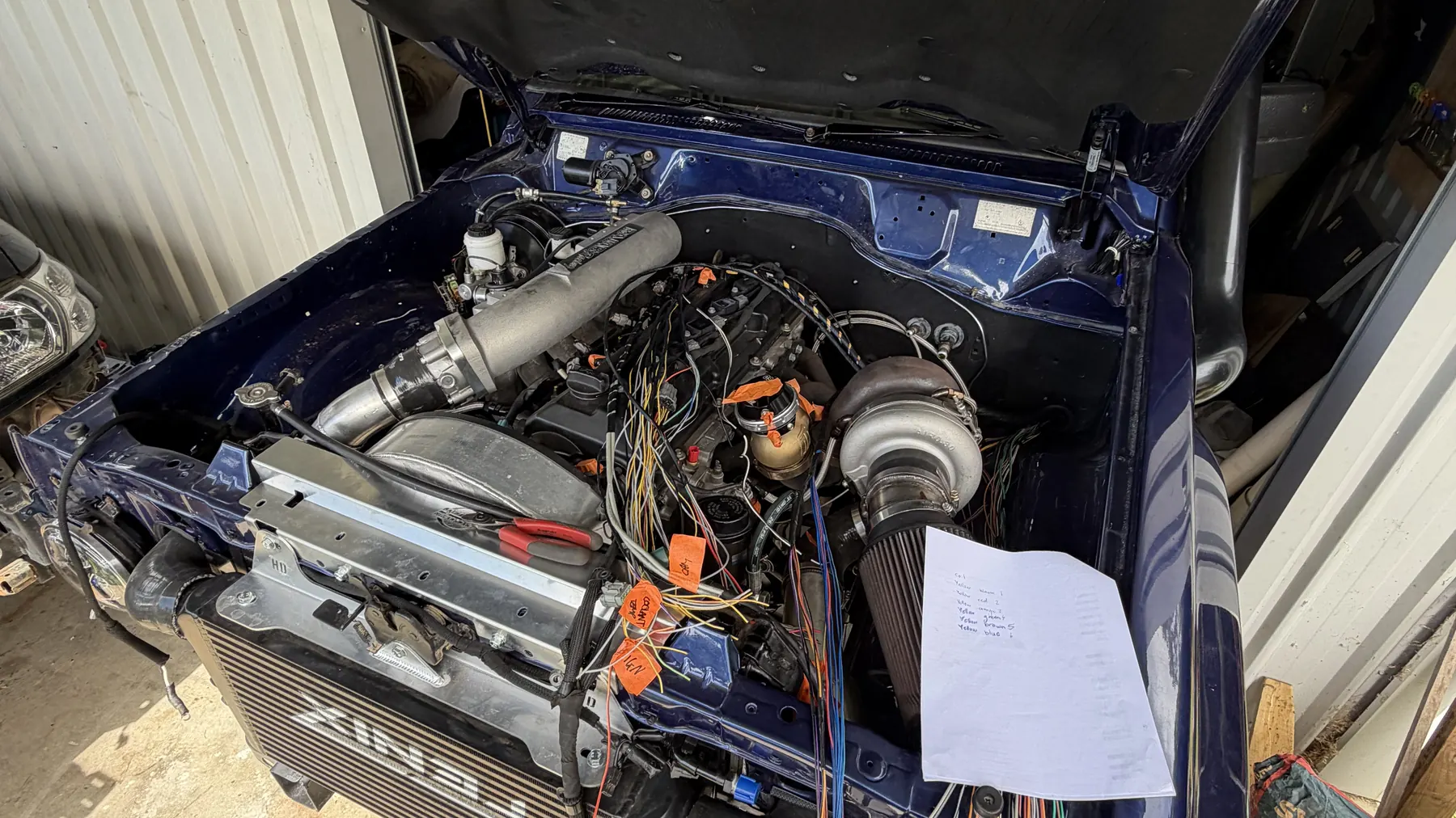Four wheel drive with the bonnet up mid-rewire, loom laid out across the engine bay